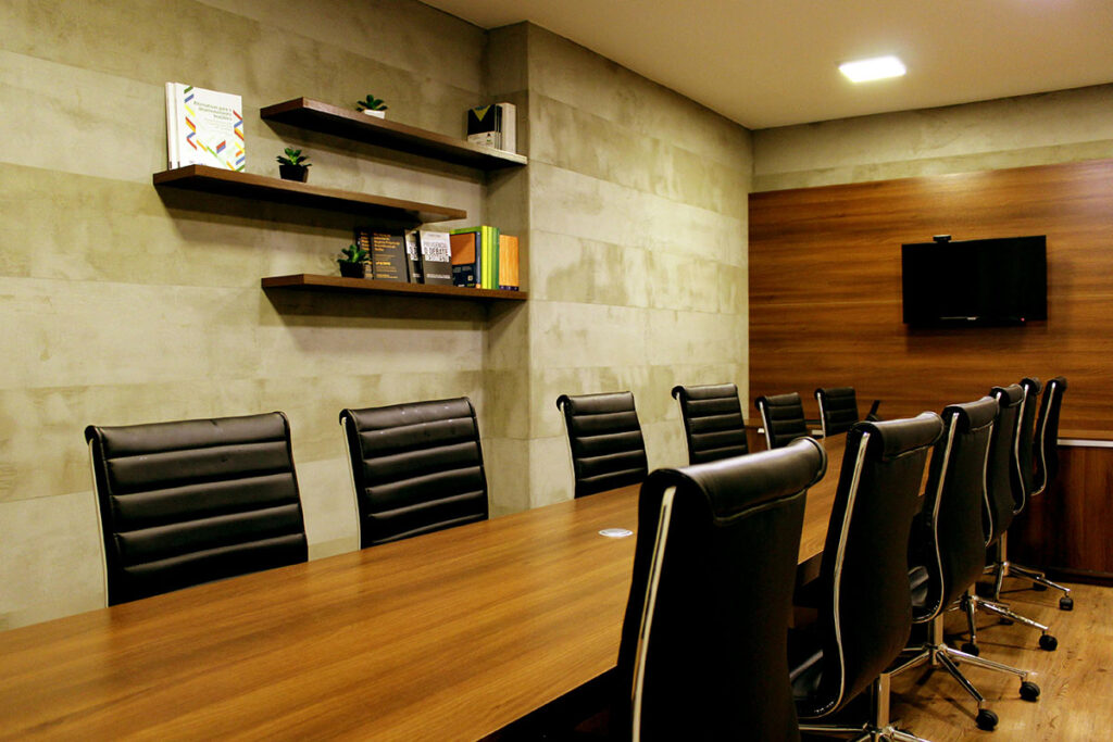 Picture of a boardroom table with a dozen chairs.